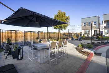 A patio with a table and chairs under an umbrella.